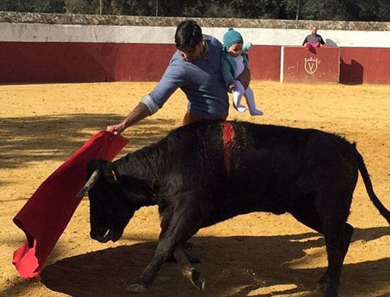西班牙鬥牛士懷抱幼女鬥牛